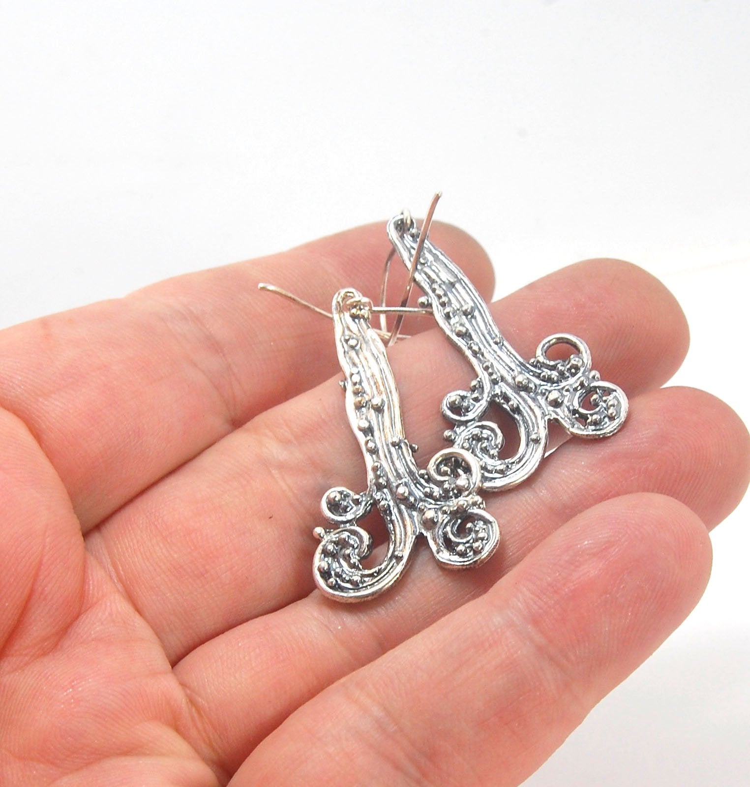 Waterfall Earrings These long Wave Dangles are part of my new work. These are cast versions of my original granulation work, which is then molded for repeat waxes and then cast using the Lost Wax process.These waterfall dangles have a dark patina and are