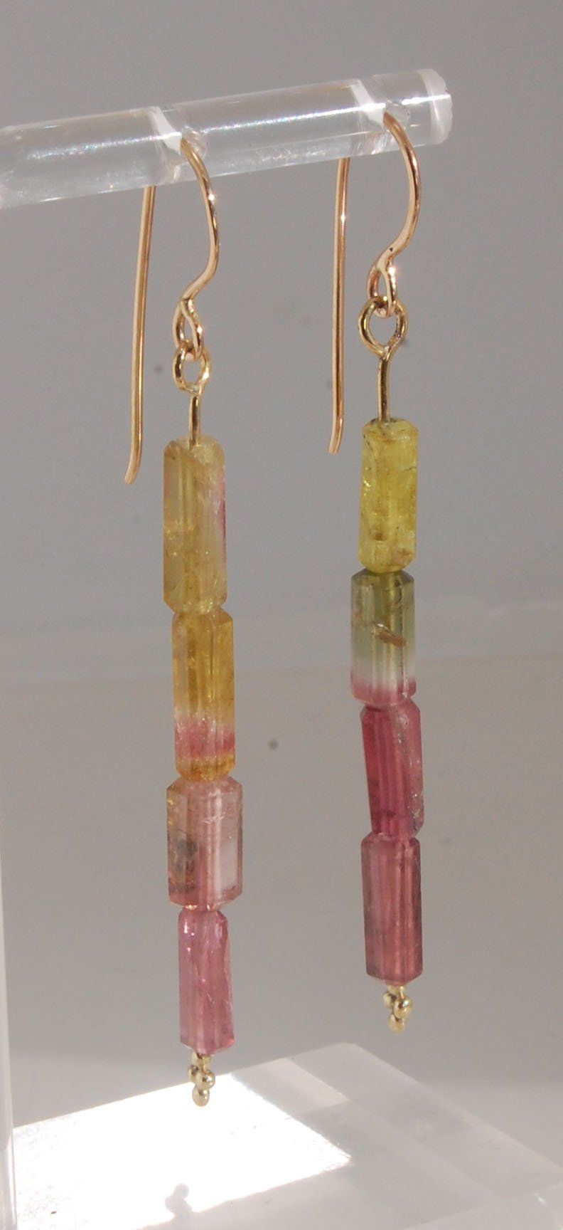 Watermelon Rind Tourmaline Dangle Earrings in 14k gold with french hooks Oh these colors! These Watermelon Rind Tourmaline Dangle Earrings in 14k gold with french hooks are made from faceted slices of natural tourmaline crystals on a 14 pin with 18k spher