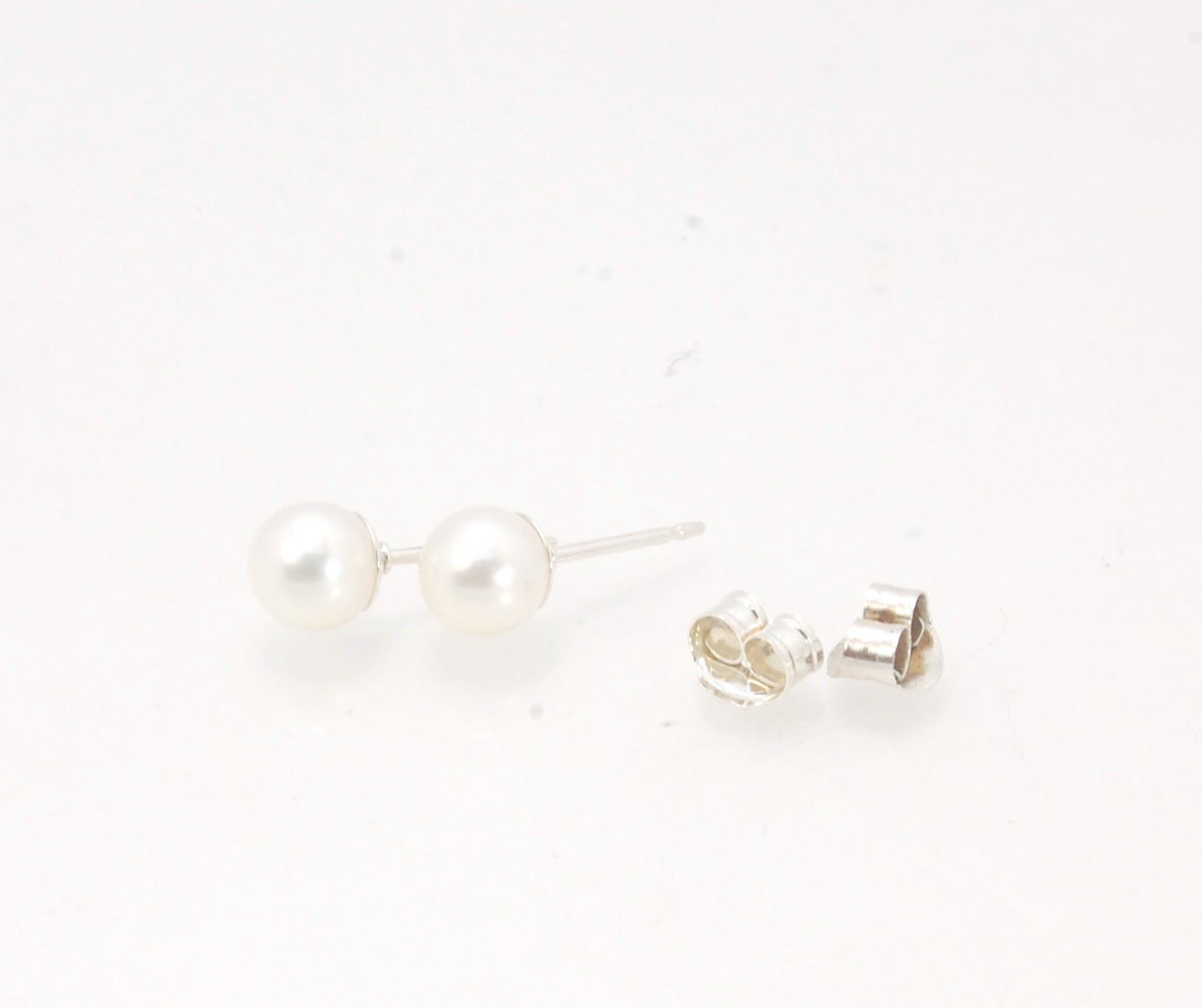 Freshwater White pearls studs in Sterling silver - 6mm These luminous white freshwater pearls are 6mm and set in sterling silver pearl cups and posts with sterling silver ear nuts.6mmSterling Silver and freshwater pearl