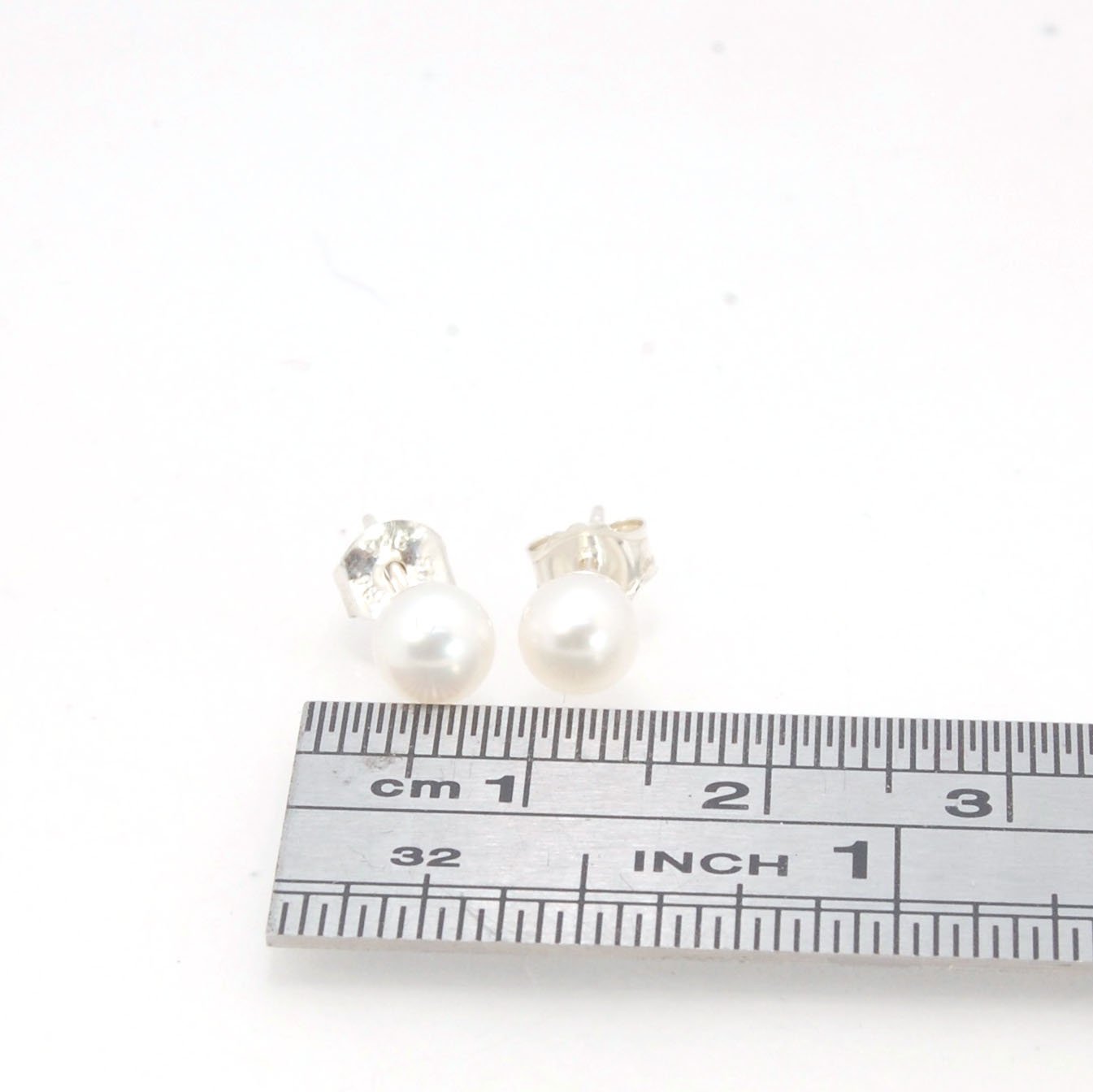 Freshwater White pearls studs in Sterling silver - 6mm These luminous white freshwater pearls are 6mm and set in sterling silver pearl cups and posts with sterling silver ear nuts.6mmSterling Silver and freshwater pearl