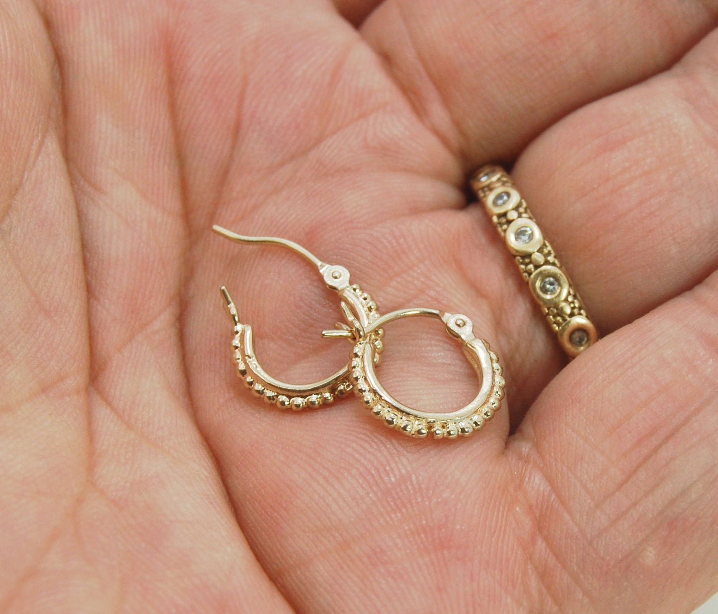 Etruscan Hoops-14k yellow gold- extra small huggies These 14k yellow gold hoops are cast in my studio (actually on the deck as casting needs good ventilation) from a granulated master for a limited edition series of hoops. I use fine silver for the origin