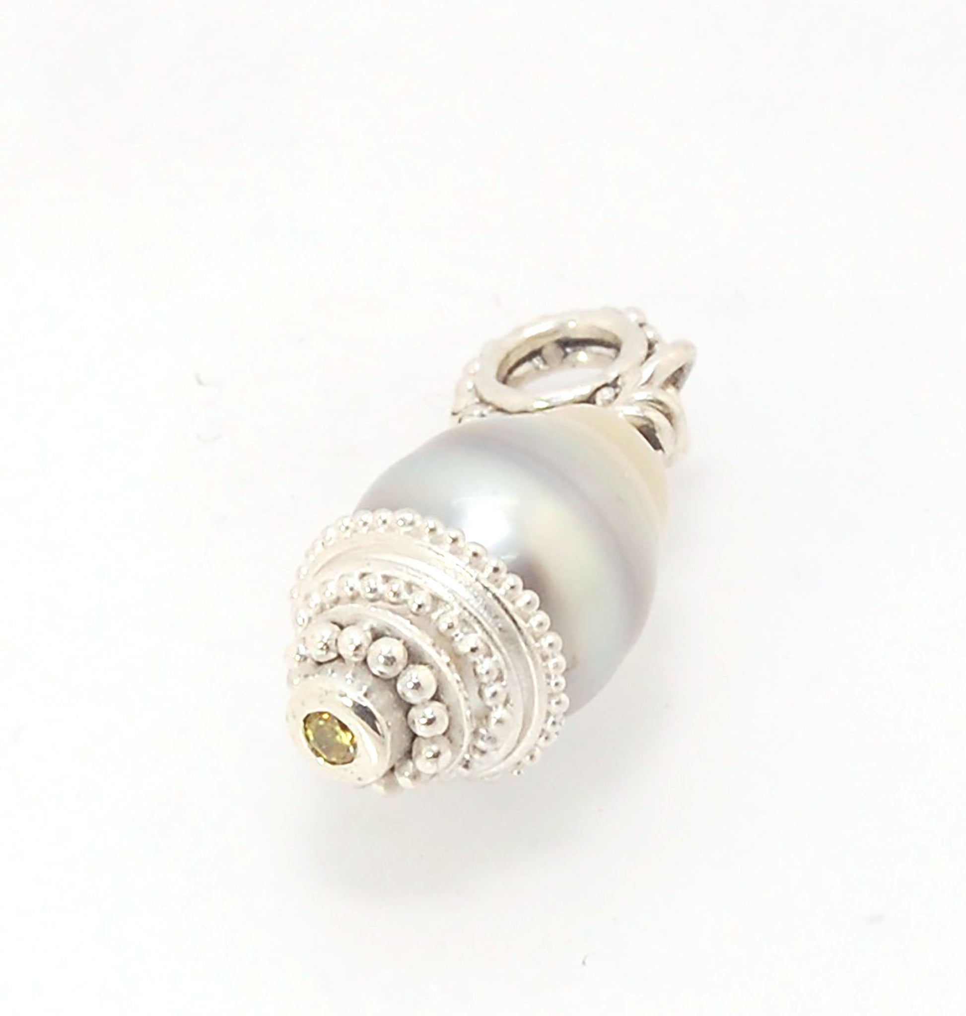 Grey Baroque Pearl with Fine Silver Granulation and Yellow Sapphire Grey Baroque Pearl with Fine Silver Granulation and Yellow SapphireThis grey baroque pearl is capped with one-of-a-kind fine silver granulation and a bezel set 2mm faceted yellow sapphire