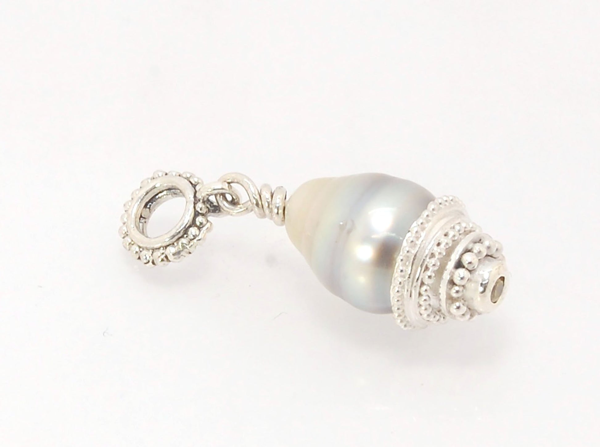 Grey Baroque Pearl with Fine Silver Granulation and Yellow Sapphire Grey Baroque Pearl with Fine Silver Granulation and Yellow SapphireThis grey baroque pearl is capped with one-of-a-kind fine silver granulation and a bezel set 2mm faceted yellow sapphire